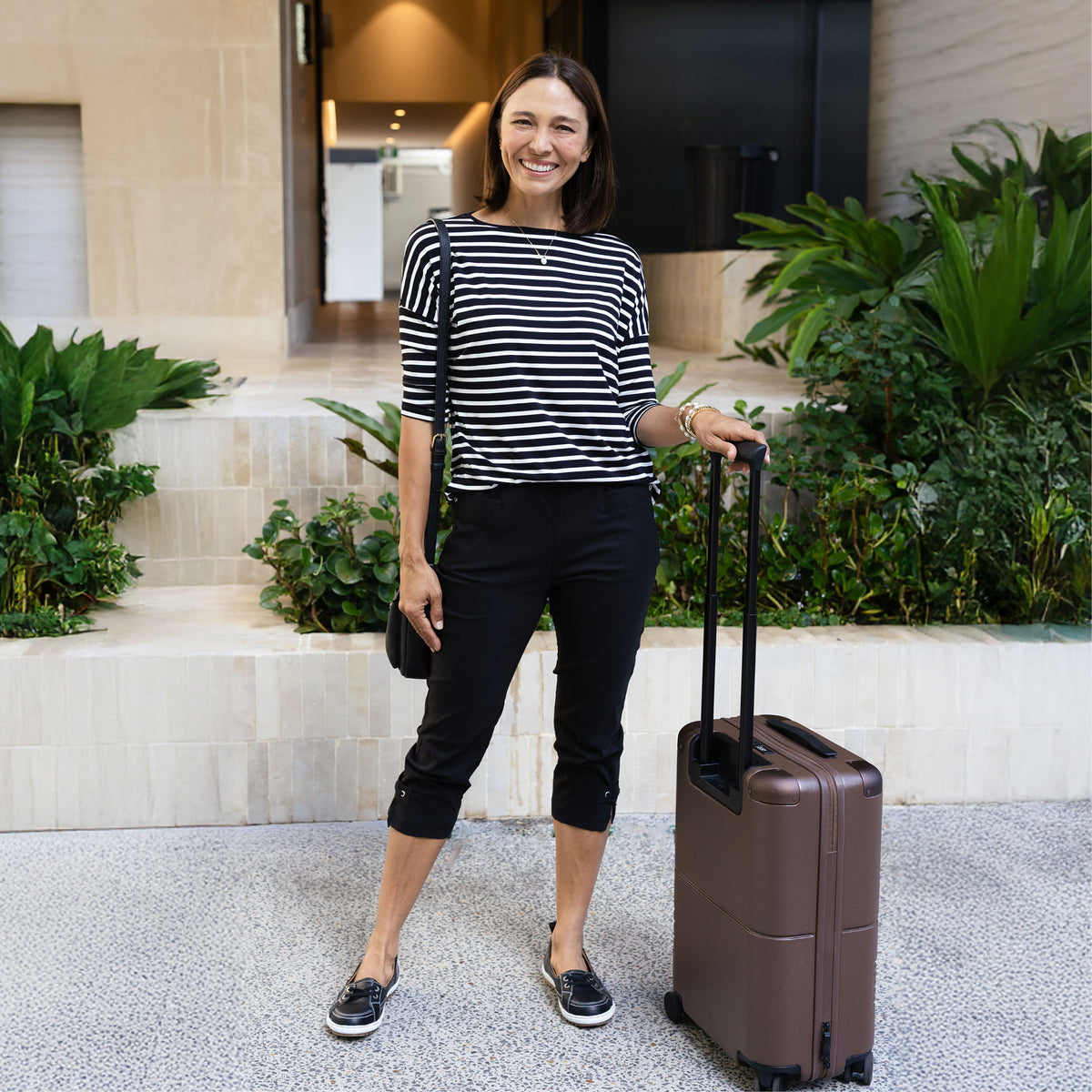 Brunette woman wearing petite friendly black cropped capri pants with pockets.
