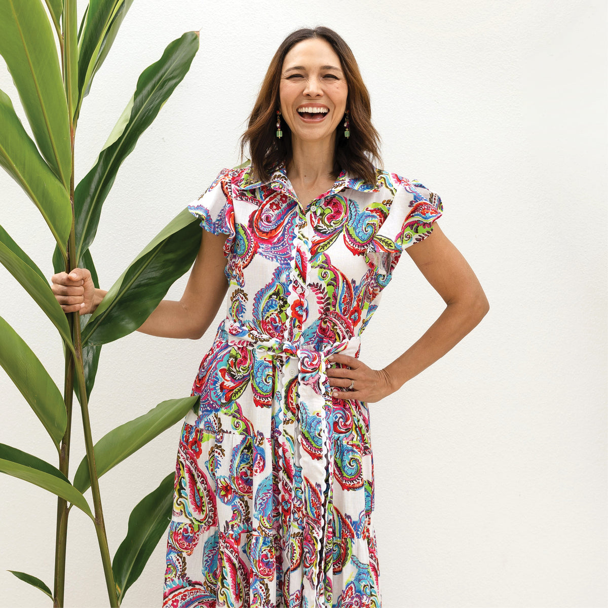 Brunette woman in a refined printed A-line dress with collar and tie 