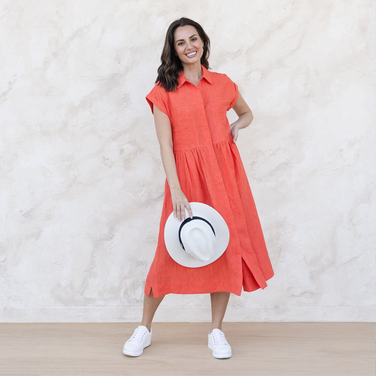Brunette woman in a casual orange shirt dress below the knee