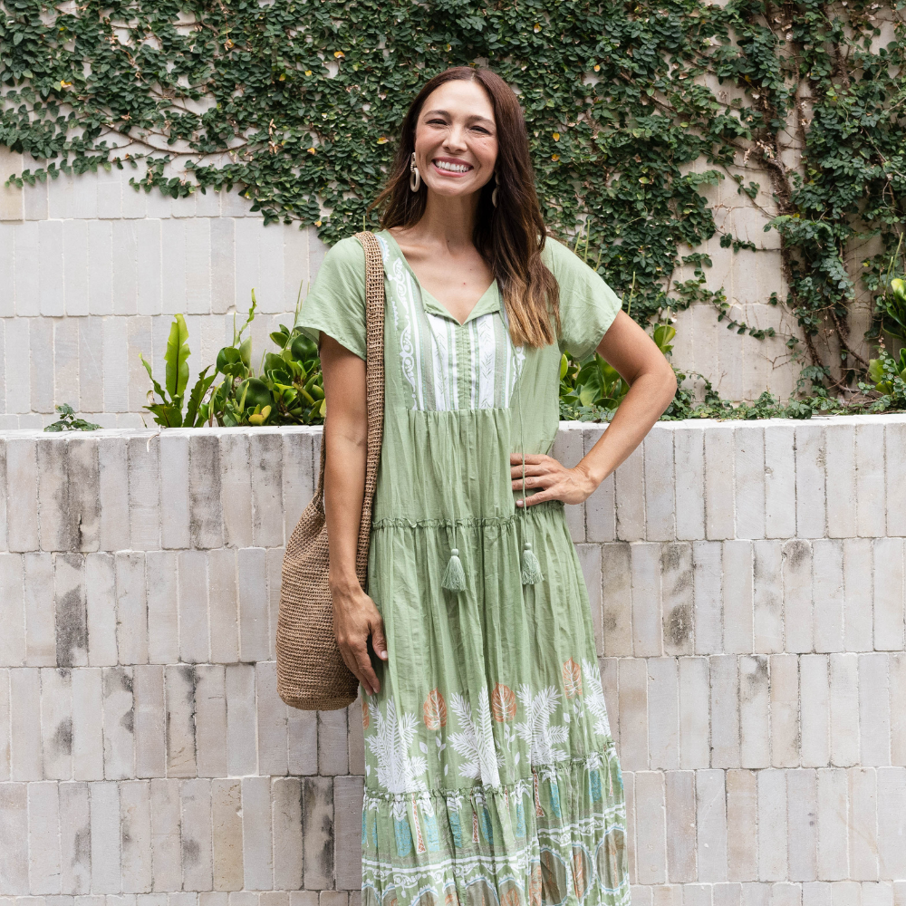 Brunette model wearing a green crinkle cotton summer dress.