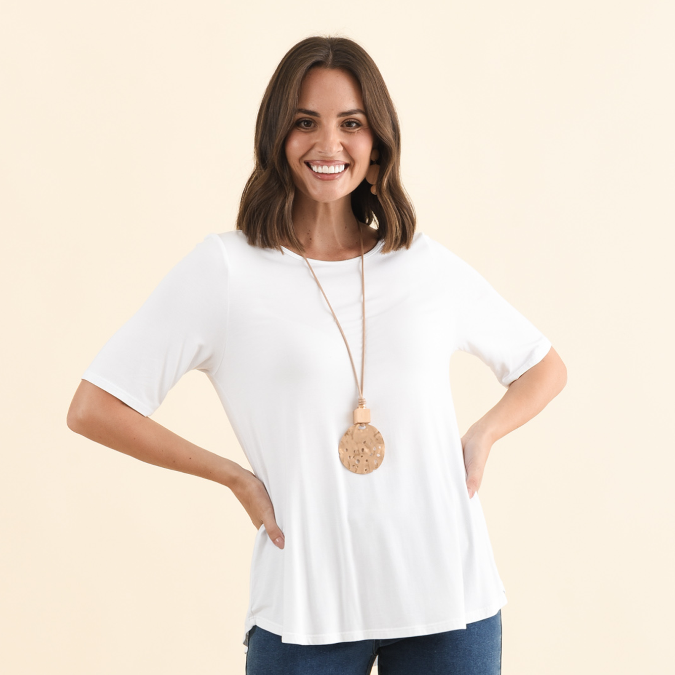 Brunette model wearing a white half sleeve tee.