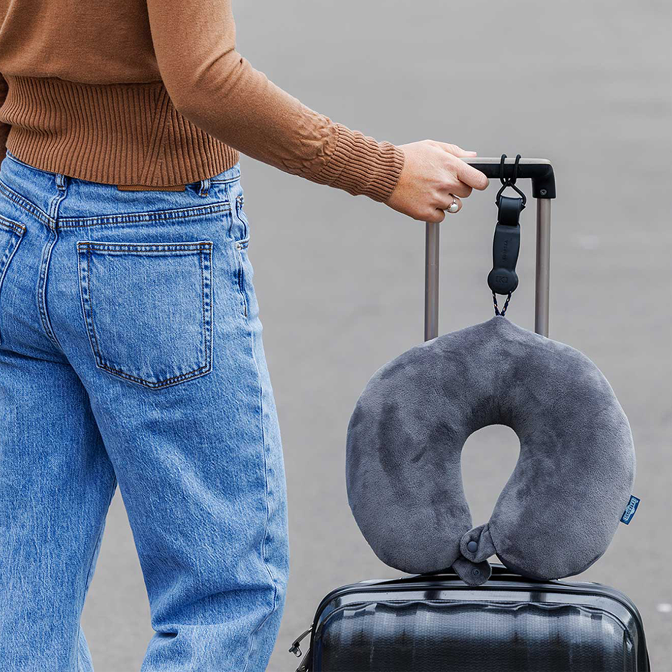 Travel neck pillow attached to a suitcase with a Klipsta hat clip.