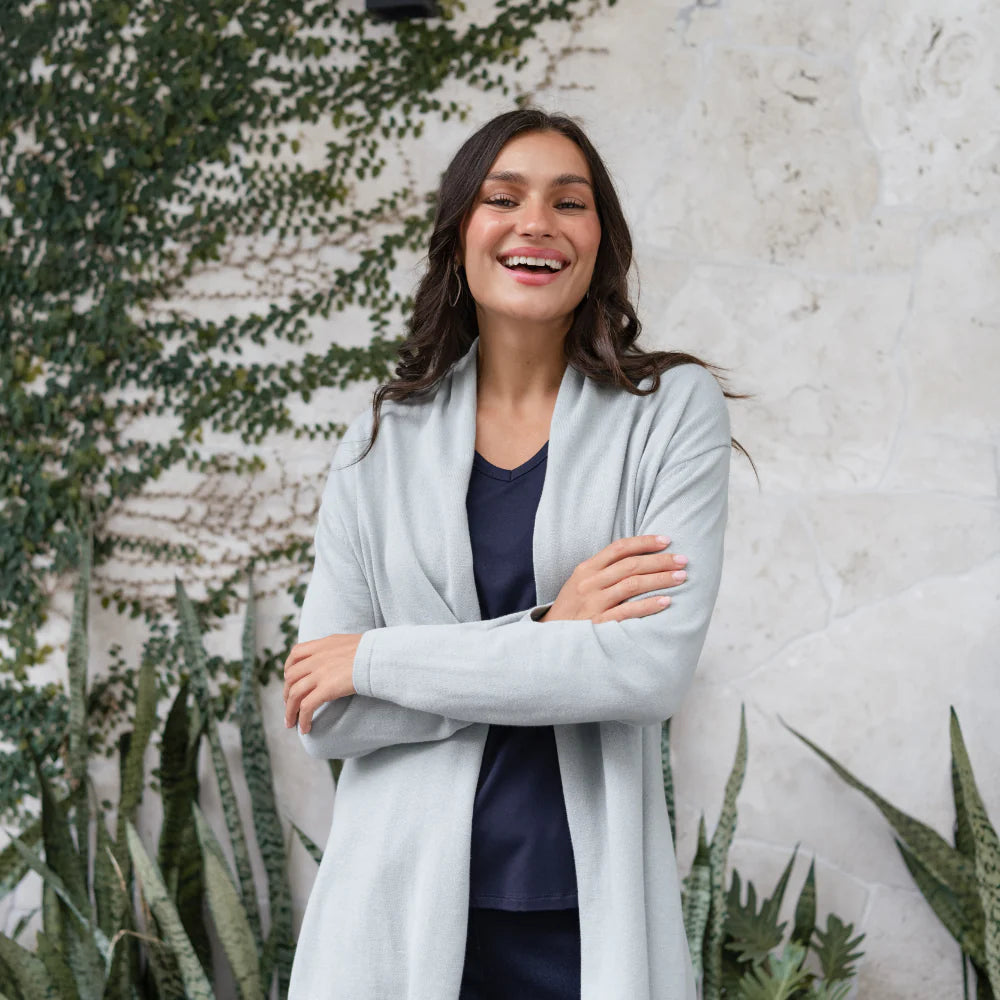 Brunette woman wearing a light blue cardigan and navy top for winter style.