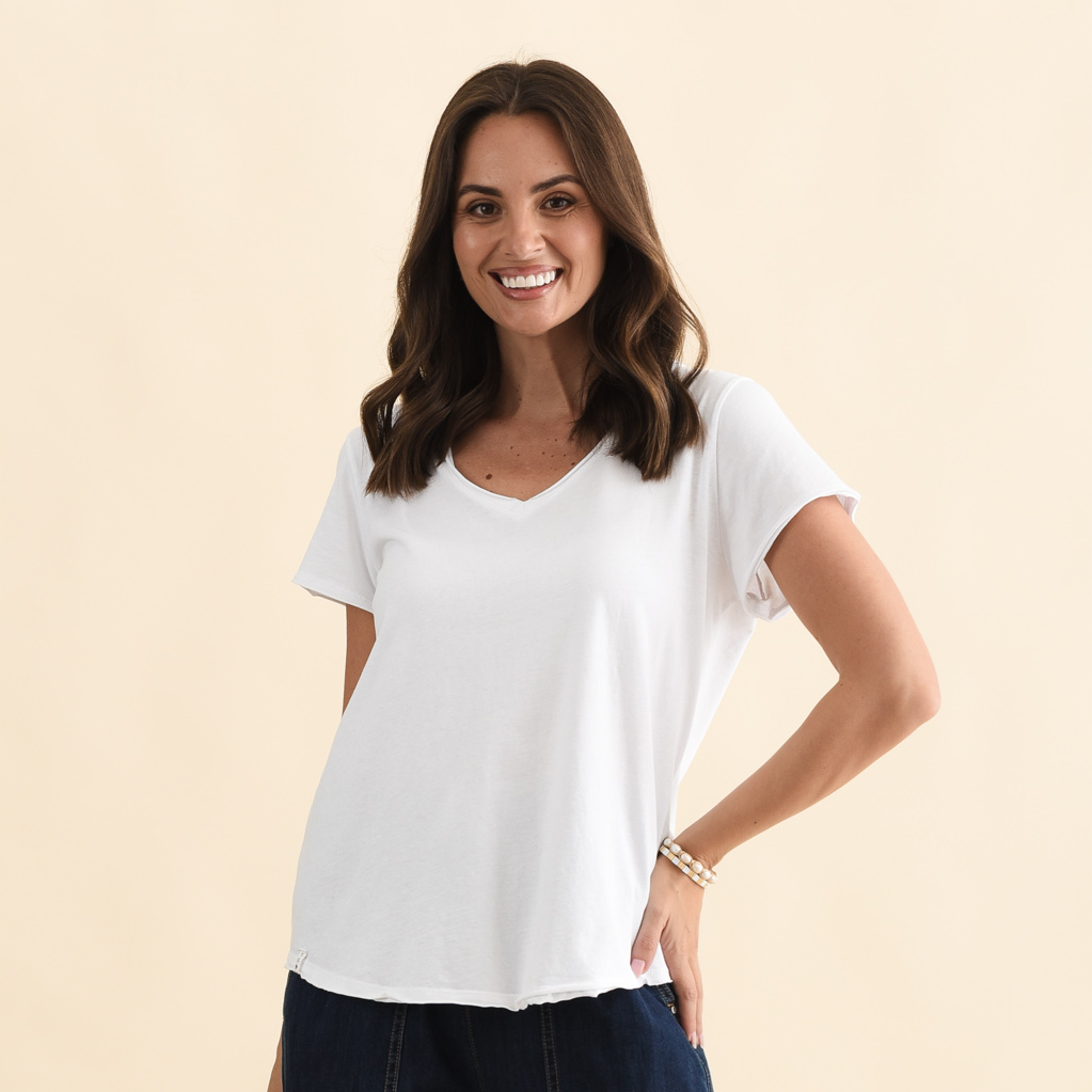 Brunette model wearing a white V-Neck tee.