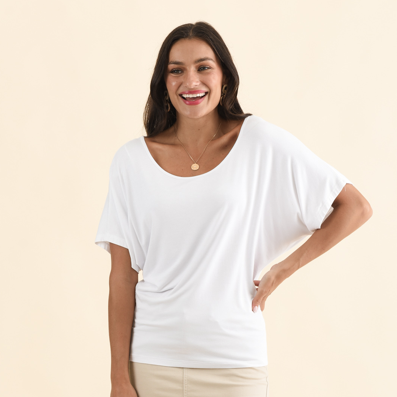 Brunette model wearing a white round neck tee.