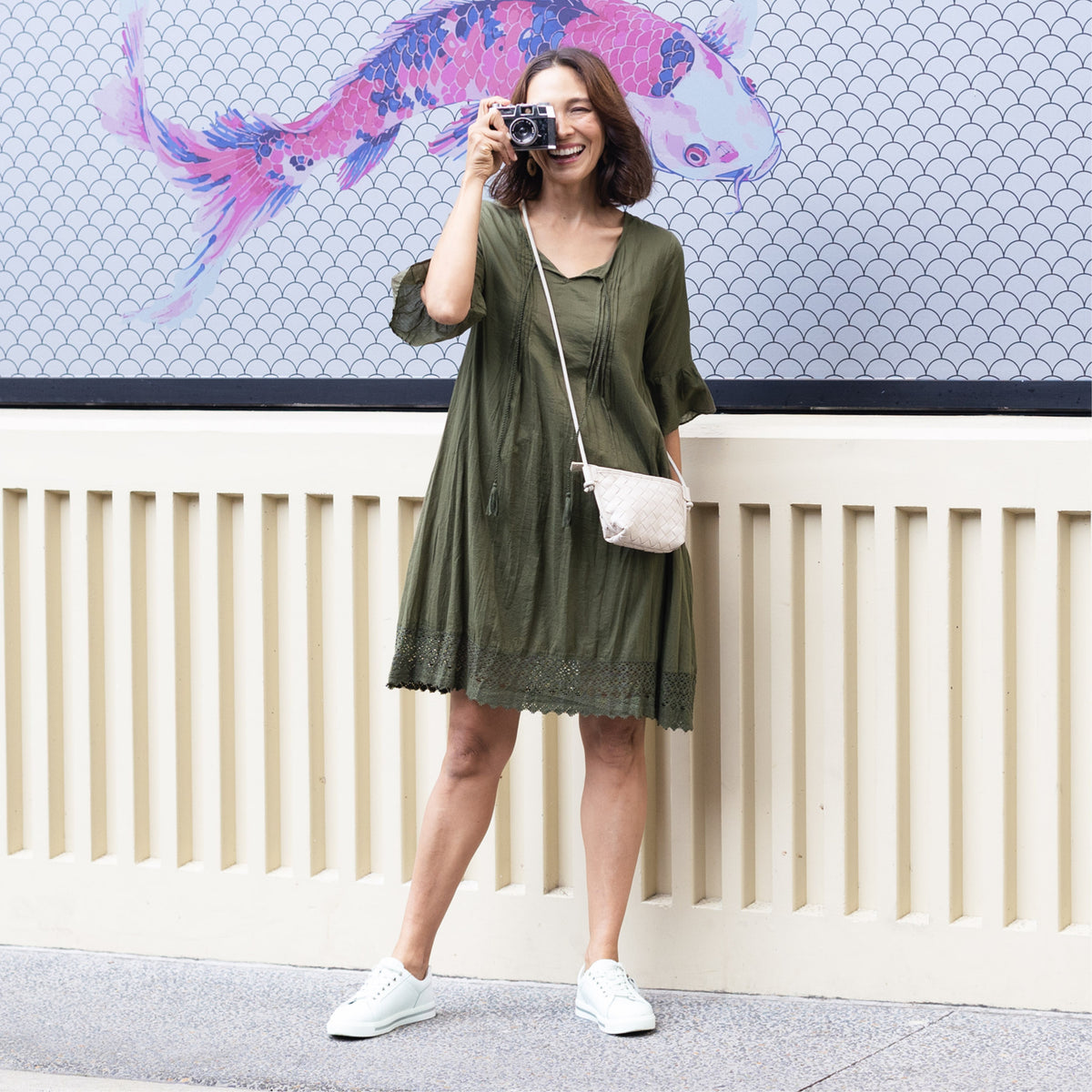Brunette women in a short green dress ideal for tropical travel